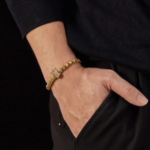 Detail of men's gold crown bracelet with micro-pave stones and textured round beads
