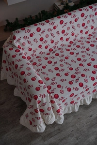 Detail of Christmas throw blanket with red ornaments and festive ruffled edges