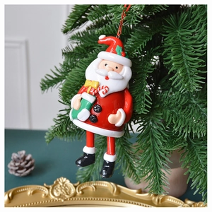 Detail of 3D Santa Claus ornament with candy cane and green sock on pine branch