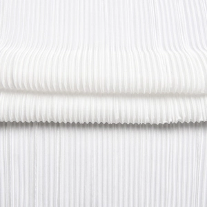 Macro shot showing white pleated fabric texture with vertical folds and soft shadow detail