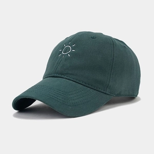 Detail of embroidered sun graphic on dark green cotton twill fabric baseball cap