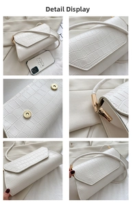 Detail view of white croc-embossed shoulder bag featuring matte gold hardware and magnetic flap