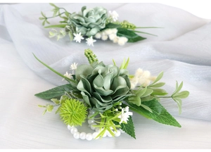 Detail of dusty green silk rose boutonniere with pearls and forest-style foliage