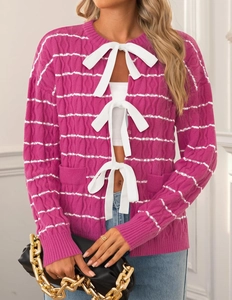 Detail of rose red knit cardigan with white bow tie closures and striped patterns