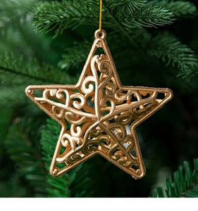 Close-up of golden hollow star ornament with vintage patterns on a green Christmas tree