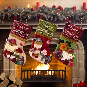 Three large Christmas stockings with Santa, Snowman and Reindeer on a fireplace