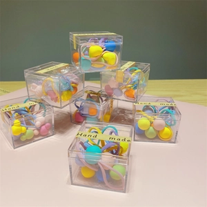 Colorful mix of heart and ball shaped hair ties for girls in a square storage box