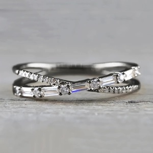 Close-up of silver criss-cross ring featuring micro-pave round and baguette cut diamonds