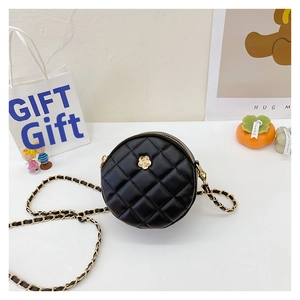 Detail of black quilted round bag featuring golden camellia floral metal clasp and chain
