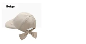 Close-up of beige cotton baseball cap featuring a large decorative bow on the back