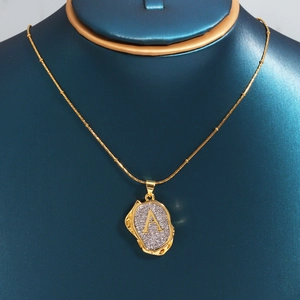 Macro shot of 18k gold plated letter A pendant with cubic zirconia on a blue bust