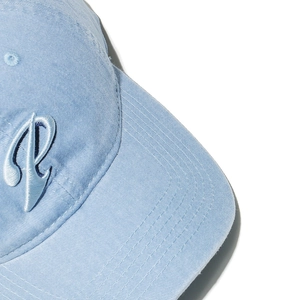 Macro detail of 3D embroidered letter P on light blue washed cotton baseball cap