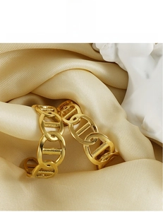Detail of 18K gold plated chain earrings on elegant satin background for women