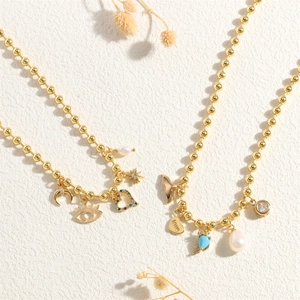 Detail of bohemian gold bead necklace with freshwater pearl and heart charms