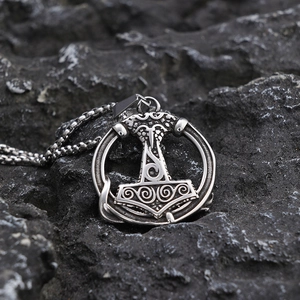 Viking Thor's Hammer pendant necklace on black stone background with metal engraving