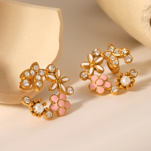 Détails macro des boucles d'oreilles fleurs en or 18K avec émail rose, perles et zircon
