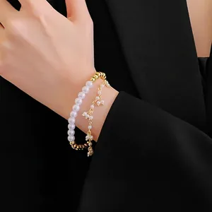Bracciale a doppio strato in oro e perle con eleganti ciondoli in strass indossato