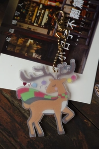 Detail of DIY Christmas deer diamond painting keychain with a cozy wood background