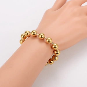 Close-up of a 10mm gold plated stainless steel bead bracelet worn on a model's wrist