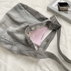 Detailed interior view of a gray tie-dye canvas tote bag with snap button and items