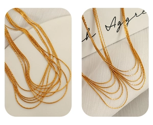 Close-up of a layered gold snake bone chain necklace with detailed metal texture and shine