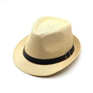 Detail of woven straw fedora hat featuring a black leather band and silver metal buckle