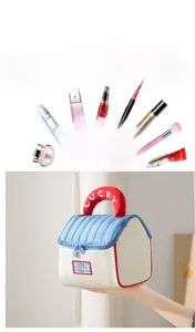 Detail view of a house-shaped makeup bag with red handle and blue patterned fabric