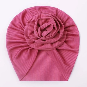 Detailed view of the pink baby turban hat featuring a large 3D rose and ribbed texture