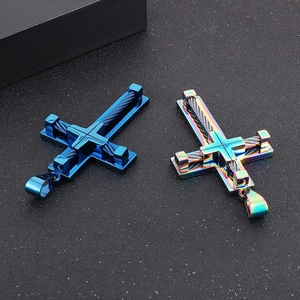 Detailed close-up of blue and rainbow stainless steel cross pendants with wire inlay