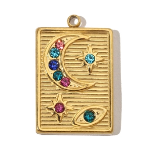 Detailed macro view of a golden moon and star rectangular charm with multicolor rhinestones