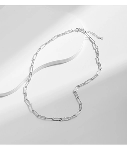 Detail of S925 sterling silver shimmering chain with a heart pendant on white stand