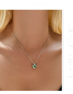 Detail view of s925 sterling silver necklace with emerald gemstone pendant on model