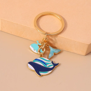 Détail du porte-clés thème baleine avec breloques en émail bleu et anneau doré brillant
