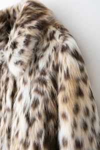 Detailed close-up of leopard print faux fur jacket showing soft texture and pattern