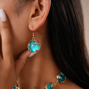 Détail du pendentif en résine bleue et boucles d'oreilles étoile de mer avec dorure