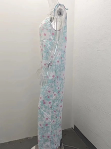 Detail of floral summer jumpsuit featuring fresh blue and pink patterns on white fabric