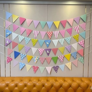 Colorful triangular bunting flags with polka dots and unicorn prints for party decoration