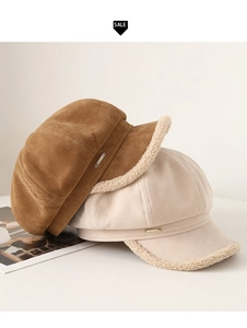 Detail of suede newsboy hat showing plush lamb wool trim and gold metal logo accent