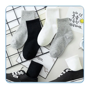 Detailed view of ribbed crew socks in black, white, and grey with cotton texture