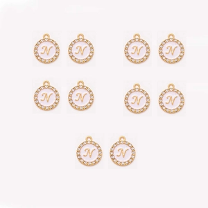 Macro view of 10-piece gold-plated round pendants with diamond inlay and letter N