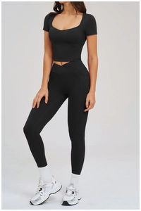 Detail der schwarzen Yoga-Leggings mit Kreuztaille, Seitentasche und bauchfreiem Top