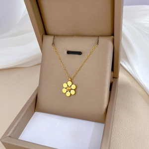 Minimalist gold six-petal flower necklace elegantly presented in a brown gift box