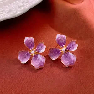 Elegant purple enamel flower earrings with white pearl center and gold-plated trim