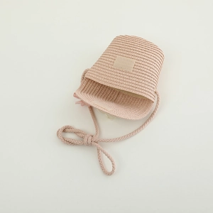 Close-up of girls pink woven straw bag with floral detail and velcro closure