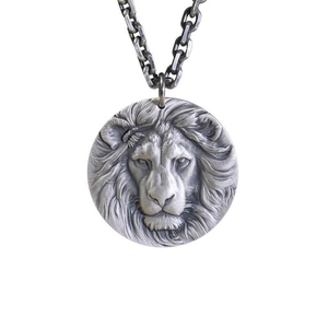 Detailed close-up of a silver lion head embossed circular pendant with thick metal chain