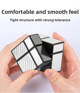 Close-up of hand holding a 3x3 silver mirror cube with brushed texture finish