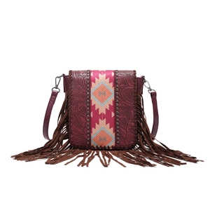 Detail of bohemian embossed leather crossbody bag with ethnic woven panel and long tassels