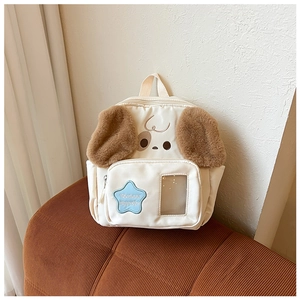 Close-up of cute puppy backpack with star patch and transparent card slot on sofa