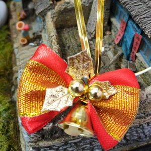 Close-up of a festive Christmas bow with gold bells and leaves for gift wrapping and pets