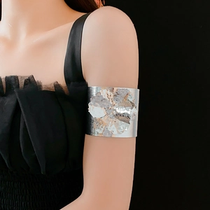 Detailed view of a silver floral upper arm cuff bracelet on a model's arm